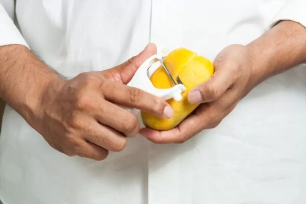 peeling mango by using peeler